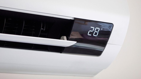close-up van vaste airconditioner met temperatuur 28 graden in led-letters erop